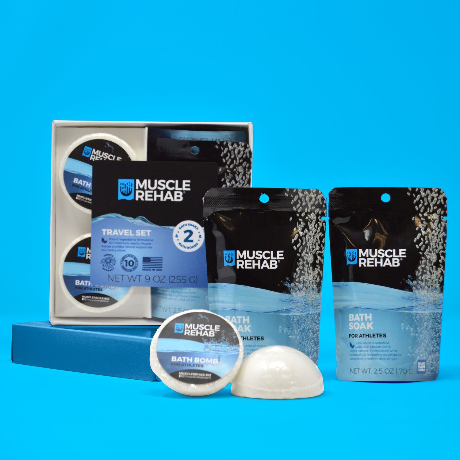 Collection of Muscle Rehab products including a travel set, bath soak, bath bombs, and bath salt on a blue background.