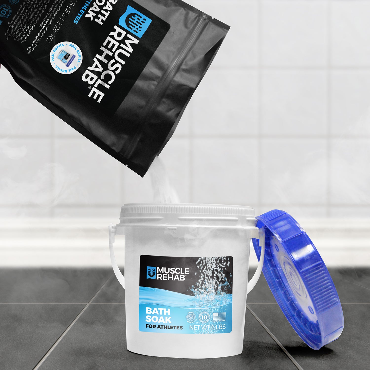 Muscle Rehab bath soak pouring out from the 5 lb Refill pouch and into a 6 lb Muscle Rehab pail on a steamy bathroom